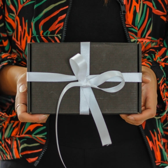 Geschenkbox mit Schleife und Schokolade, wird übergeben an Geschäftspartner von Podigee als Geschenk