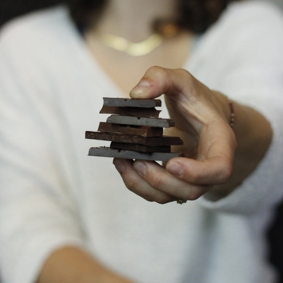 Frau hält einen Stapel mit Schokoladenstücken in der Hand für das Schokoladentasting beim Teamevent von babbel